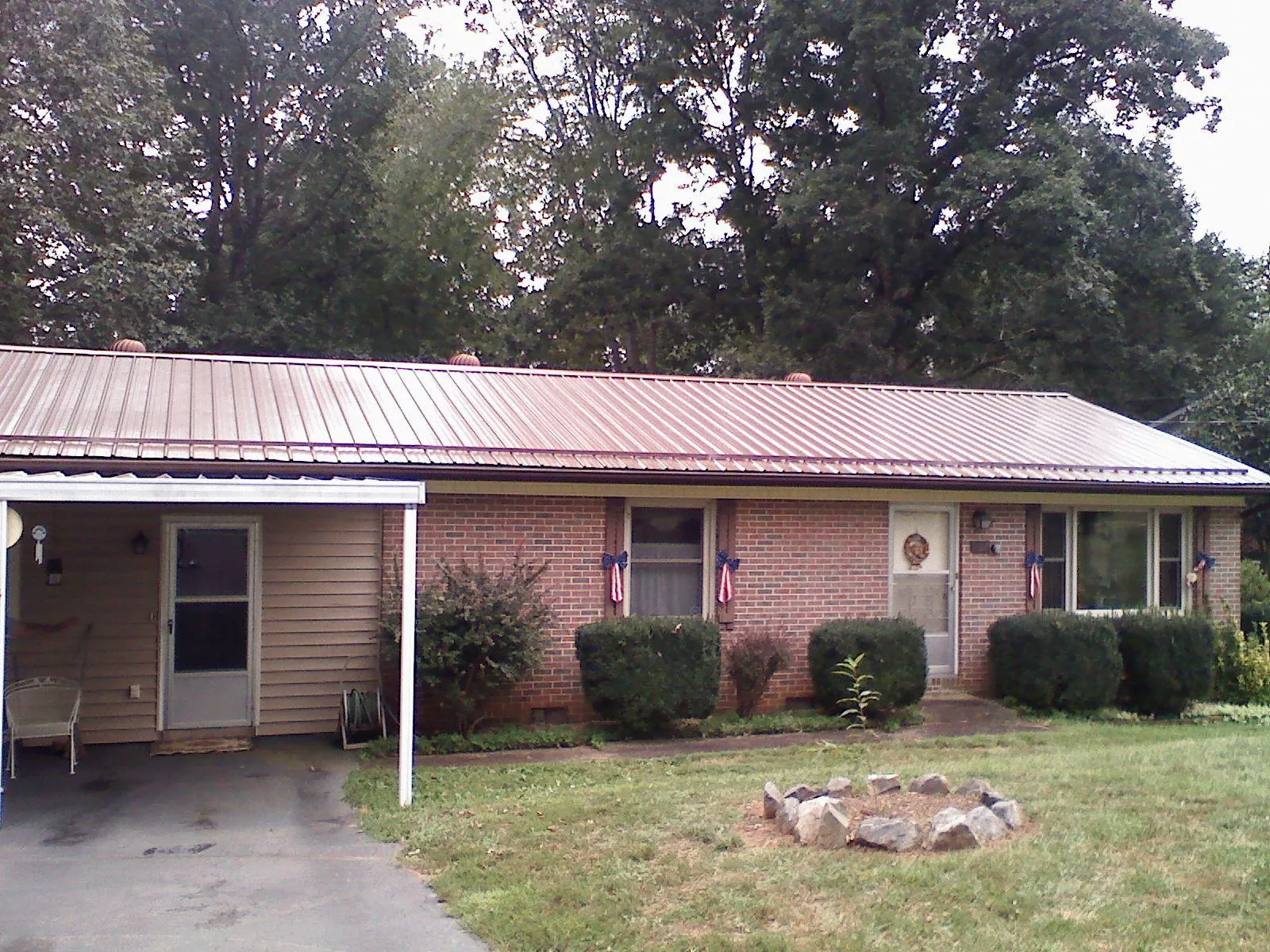 Bronze metal roof and carport on a brick ranch home — Roof Repair work by our crew in Lakeland